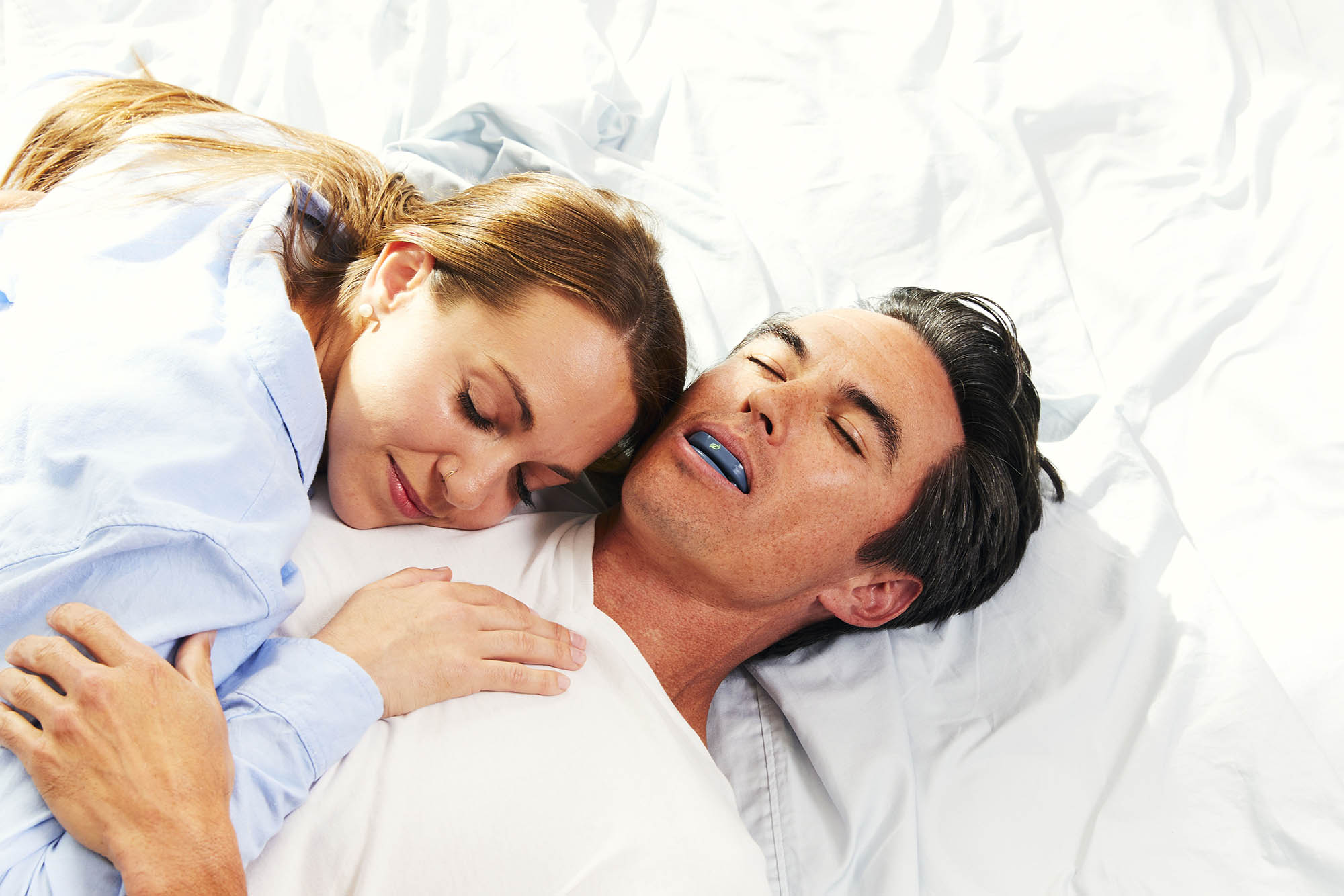 Couple happily sleeping, man wearing ZYPPAH.